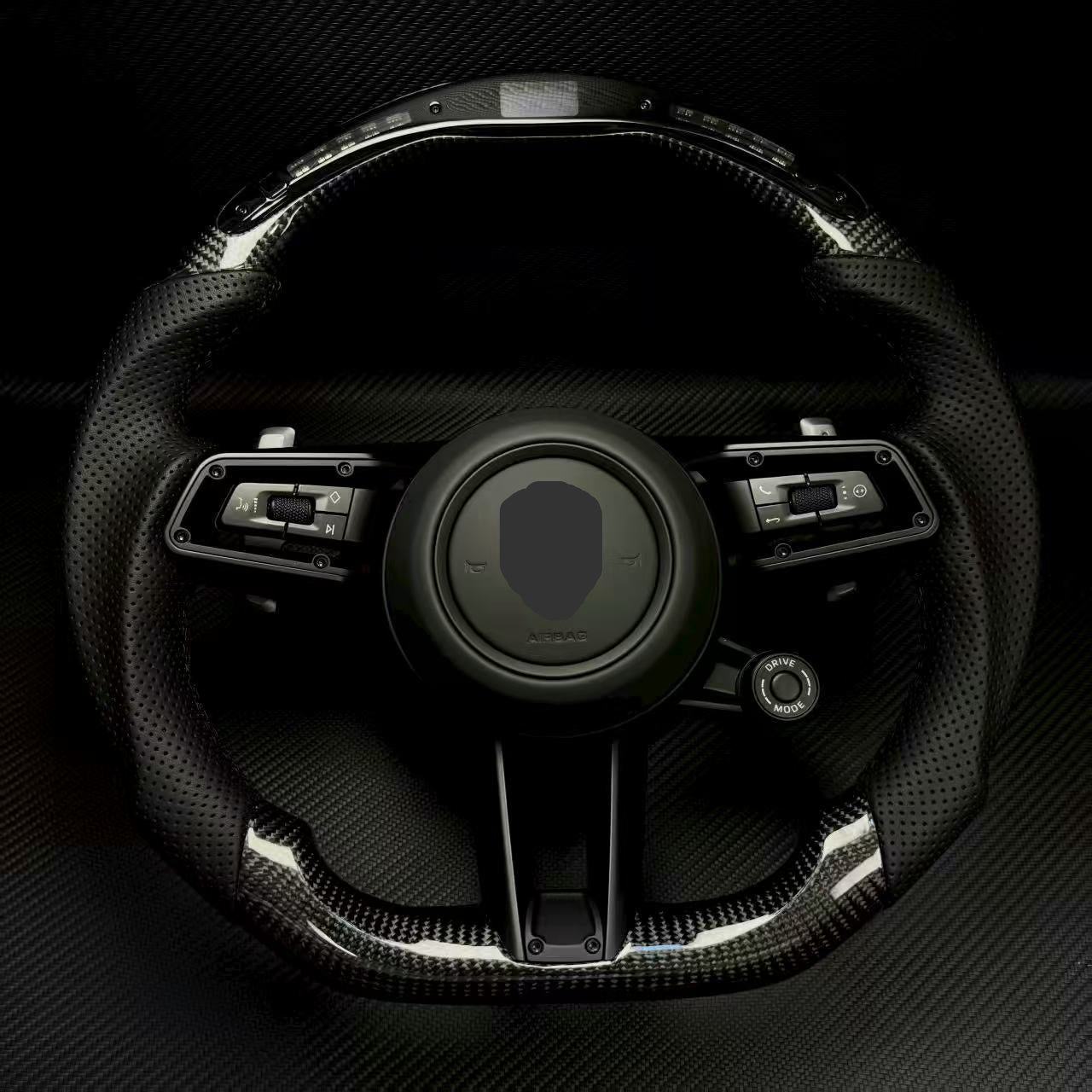 Steering wheel with Porsche logo on a dark background